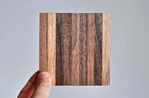 Square wooden coaster on a warm brown wood grain surface showing the flat hardwood surface used for durable custom drink coasters and wooden coaster plans.jpg Square wooden coaster on a warm brown wood grain surface showing the flat hardwood surface used for durable custom drink coasters and wooden coaster plans.jpg