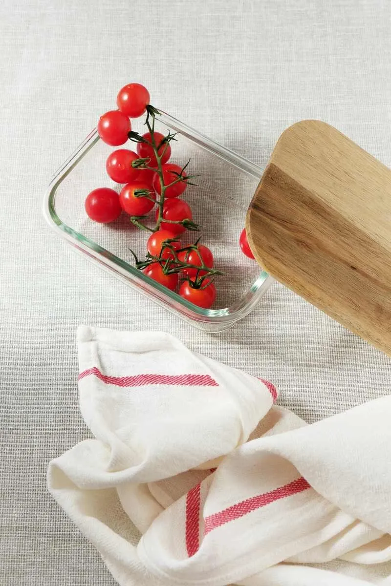 Tomato glass container with the towel next to it Tomato glass container with the towel next to it