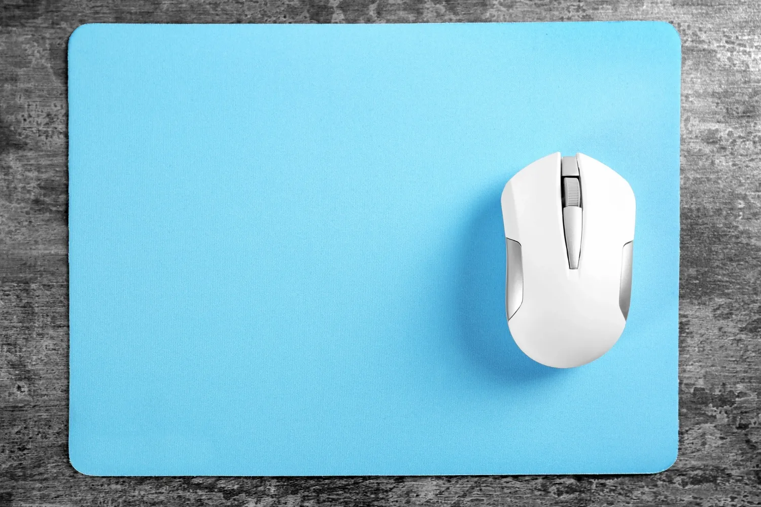 Blank mouse pad and wireless mouse on textured background