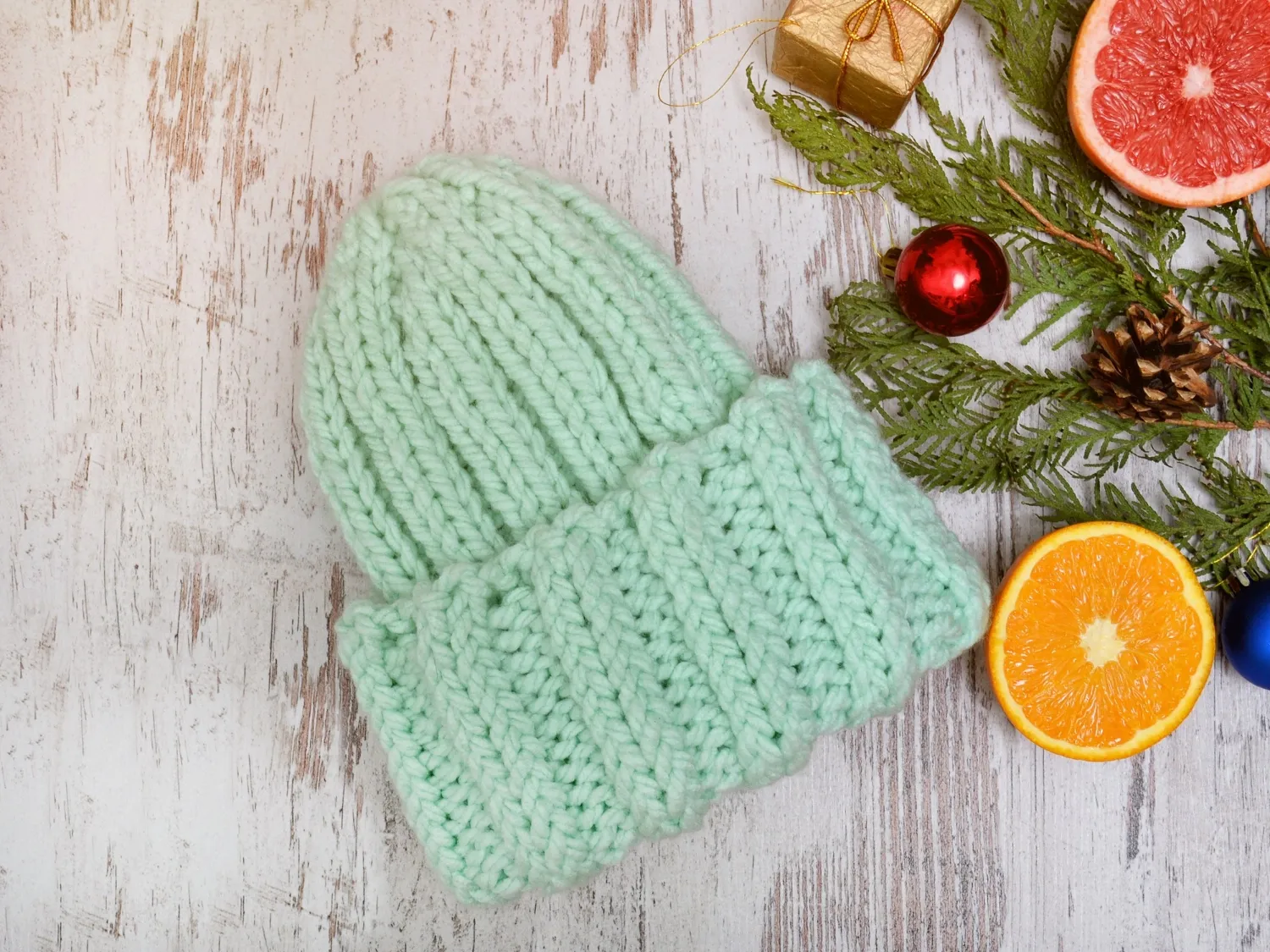 Green hat, citrus fruits and christmas tree decorations