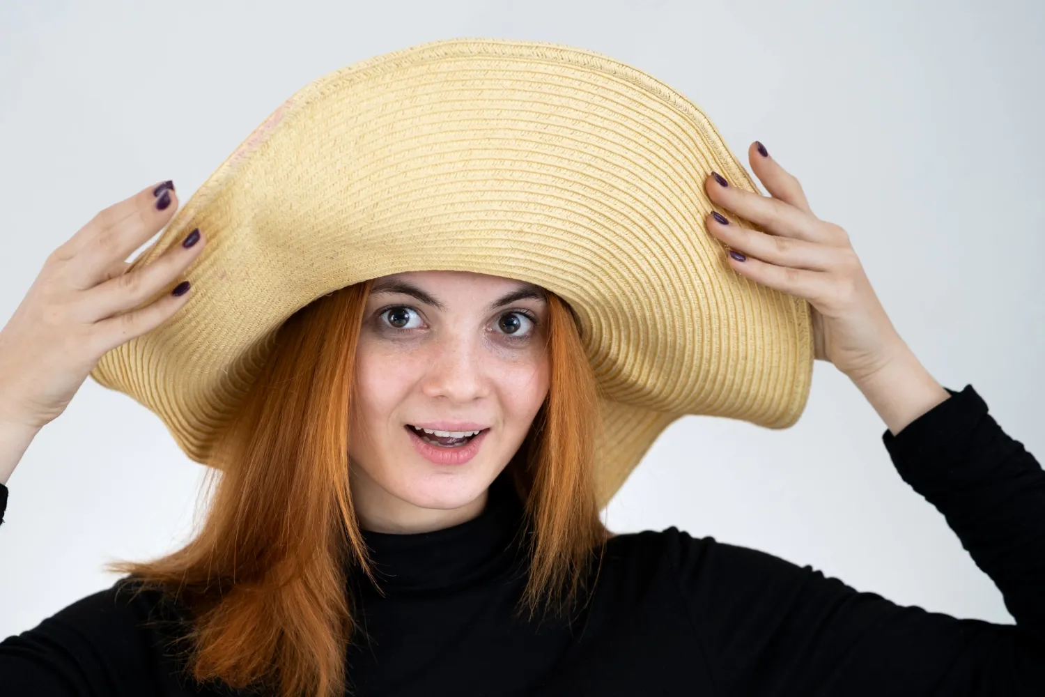 Portrait of funny redhead woman in bag yellow straw hat