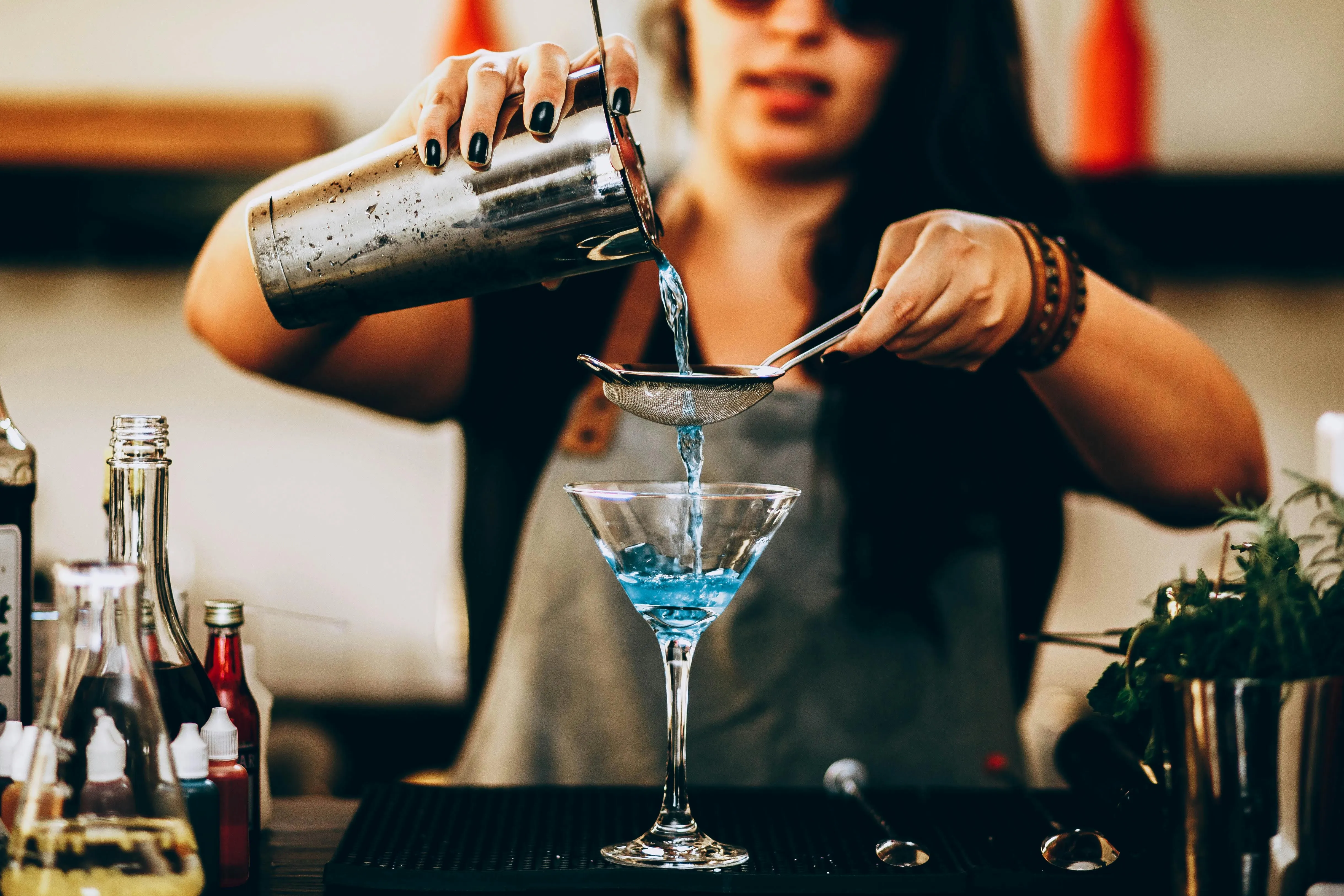 a woman making a cocktail for best liquor gift for a woman