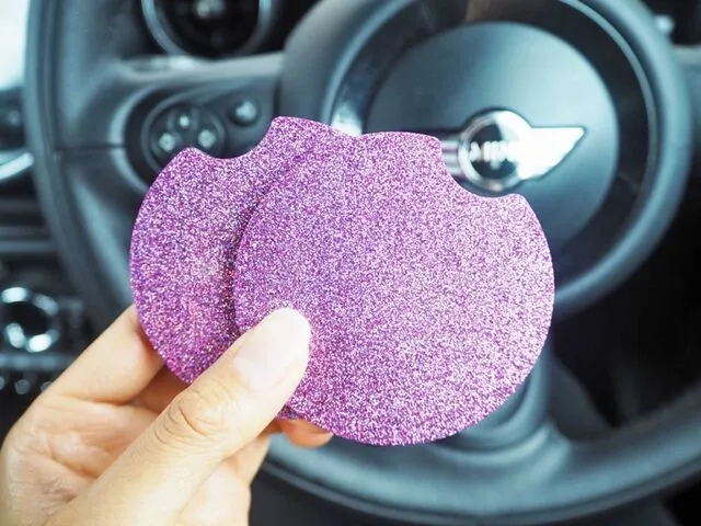 a hand holding a pair of car coasters with a pink sparkly design for car coaster designs