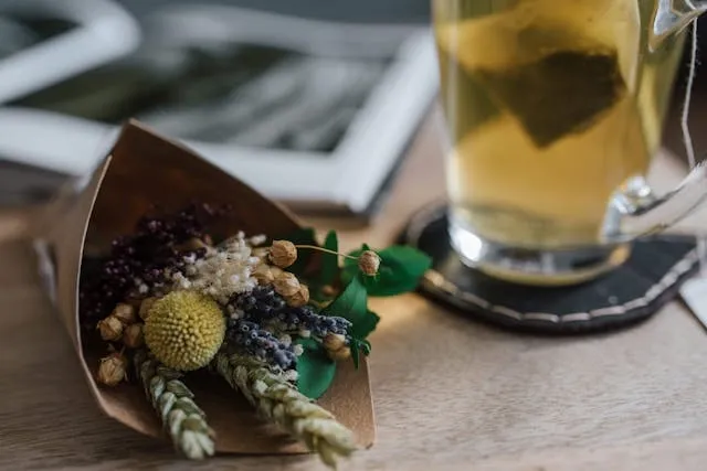 a glass on a coaster next to some dried flowers for how to make fabric coasters