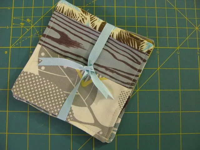 a stack of homemade fabric coasters for how to make fabric coasters