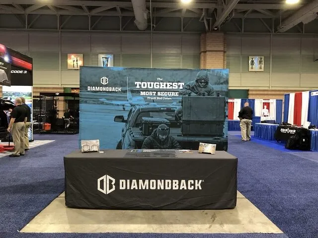 a sleek trade show booth with a black tablecloth for designing a trade show booth