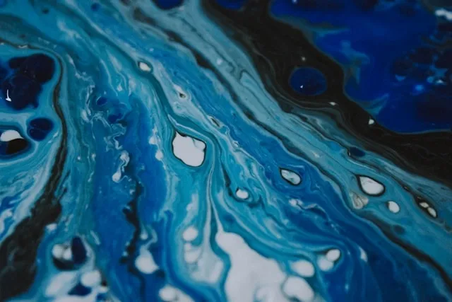 a marbled effect created with blue and white acrylic paints for coaster painting ideas