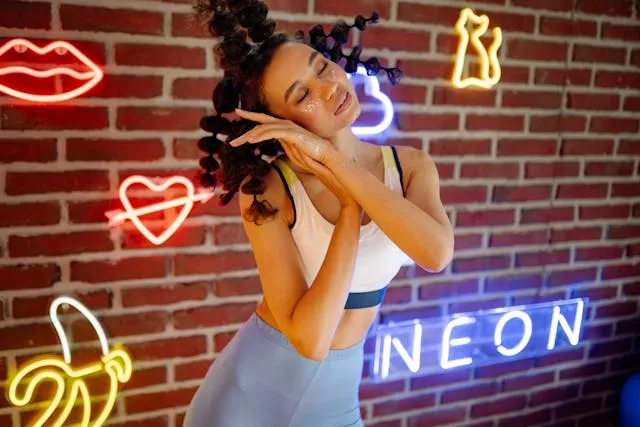 a woman standing in front of a neon sign wall display for neon theme party