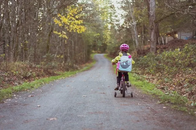 a child wearing a backpack while riding a bike for how to customize backpack