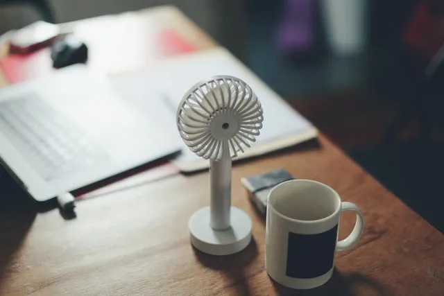 a portable fan on a desk for can you bring a fan on a plane