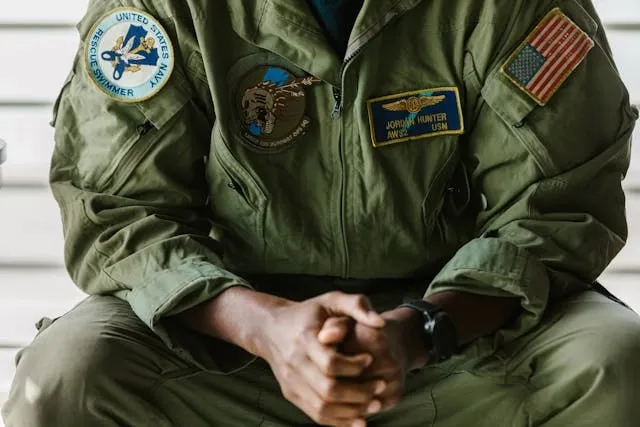 a person in military uniform sitting to display their patches for army patches meaning