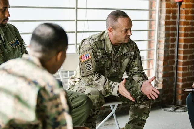 several military personnel having a discussion while seated in full uniform for army patches meaning