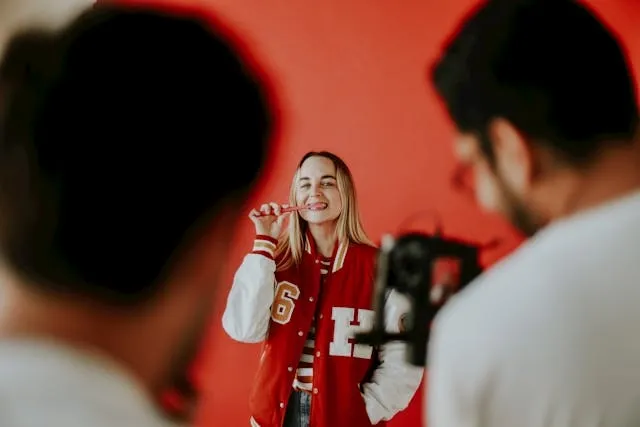 a woman posing for a photograph while wearing a red letterman jacket with patches for how to make chenille patches