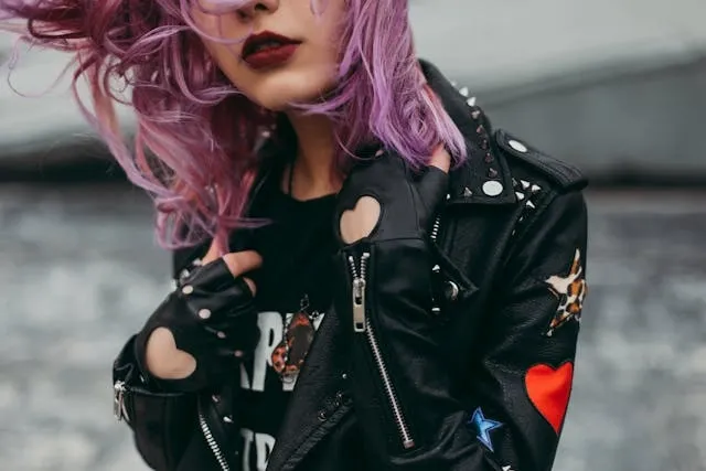 a woman with pink hair wearing a leather jacket with handmade patches for punk patch ideas