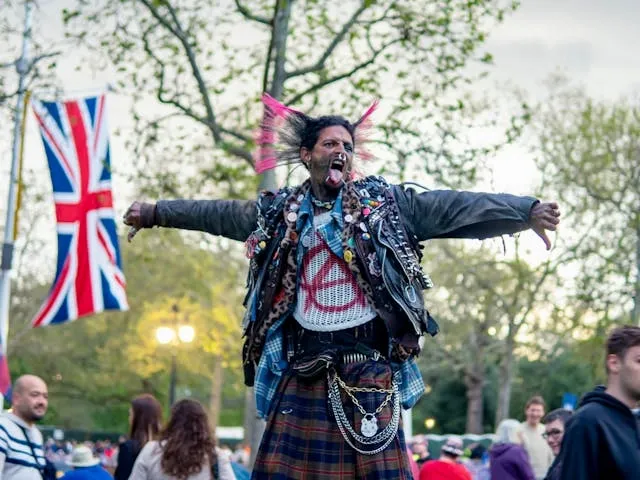 a man with wild colored hair wearing clothes adorned with patches and buttons for punk patch ideas