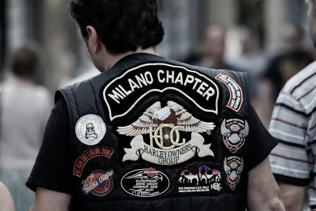 a man wearing a leather vest with multiple patches for can you put patches on leatherr