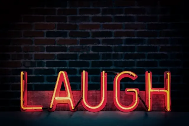 a striking red neon sign with the word laugh for aesthetic neon quotes