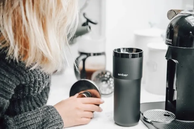 a woman beside a metallic tumbler and coffee machine for tumbler ideas for ladies