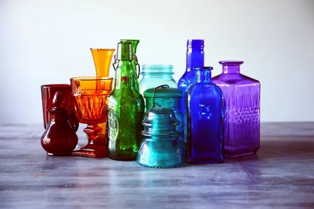 a selection of colored glass containers on a table for low-cost wedding table decorations