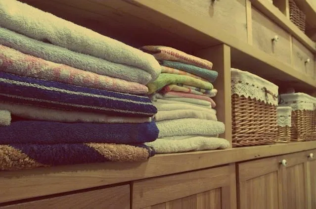 towels and linens on shelves for tablecloth storage ideas