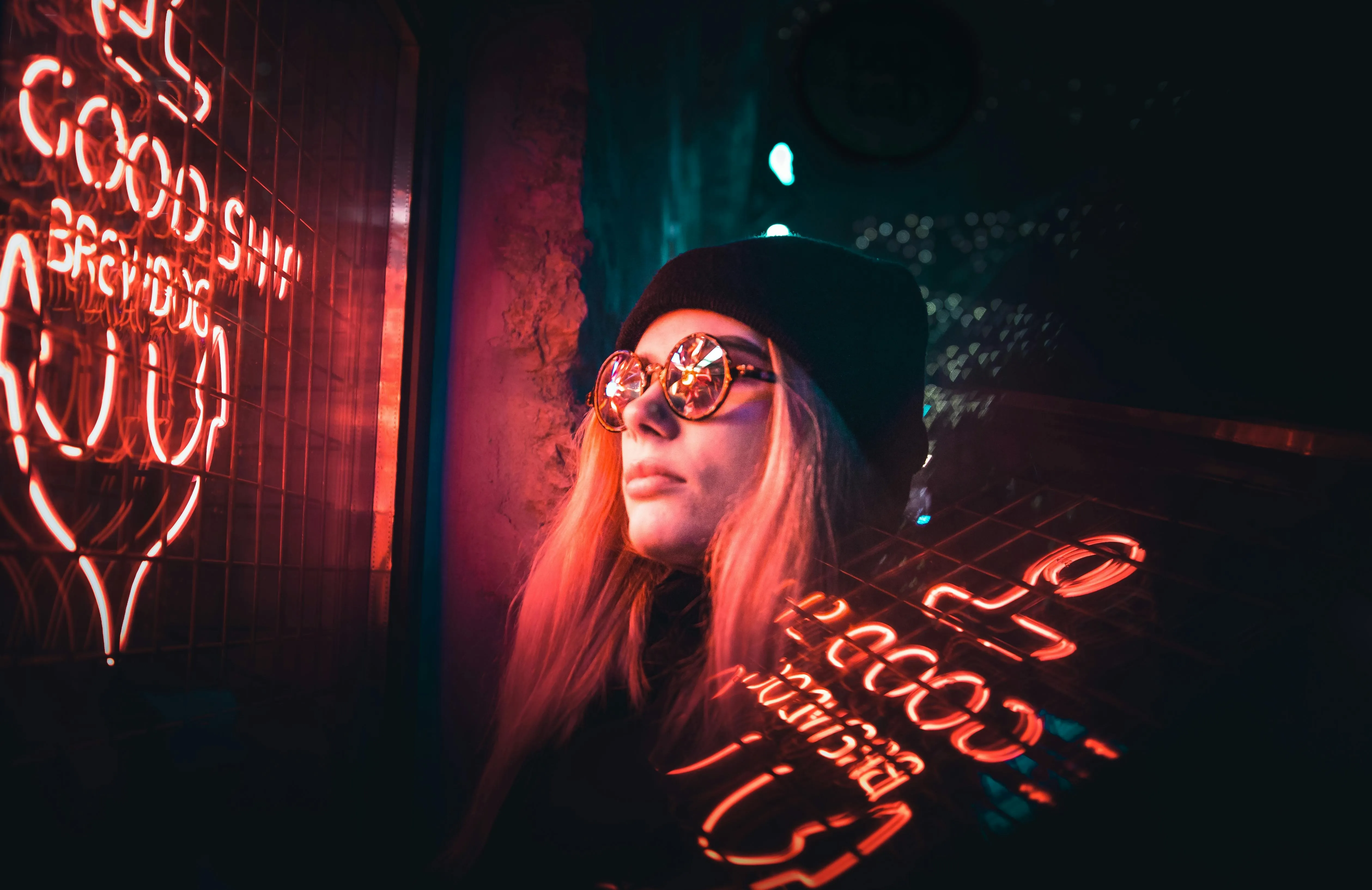 a woman looking at a red neon sign in a dark space for does neon glow in the dark