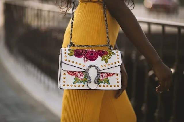 a woman carrying a high-fashion bag with ornate embroidery for best embroidery machine