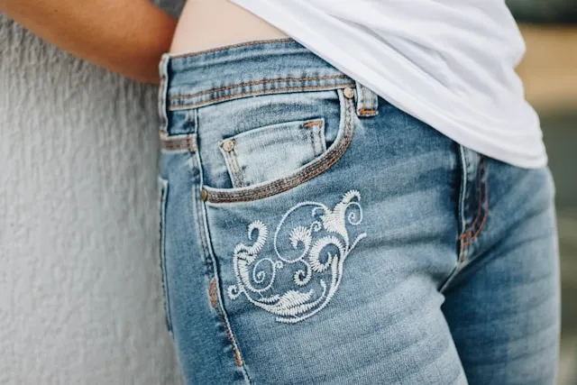 a woman wearing a pair of jeans with some delicate embroidery for creative ways to patch jeans