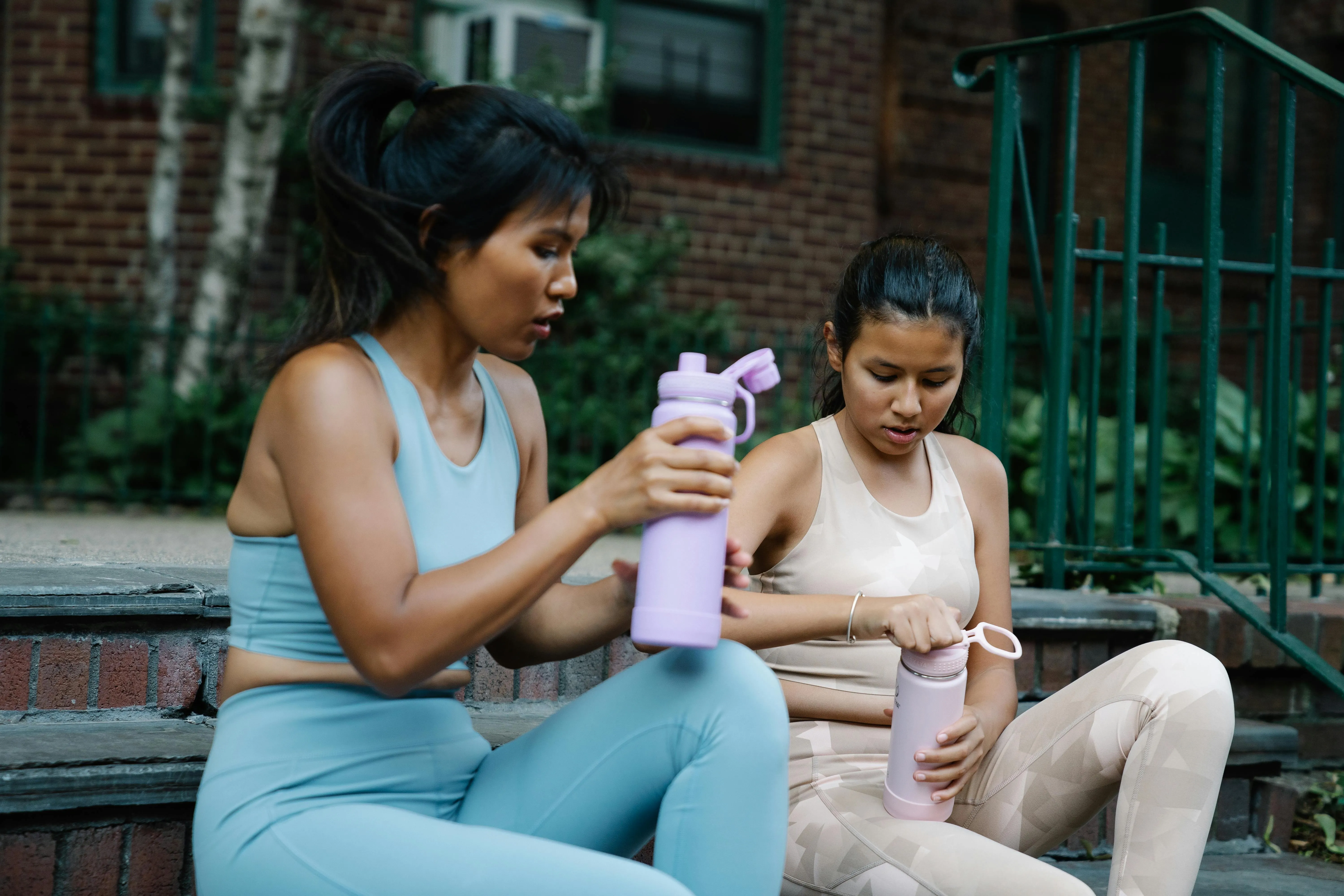 two women in athletic gear holding tumblers for tumbler engraving ideas