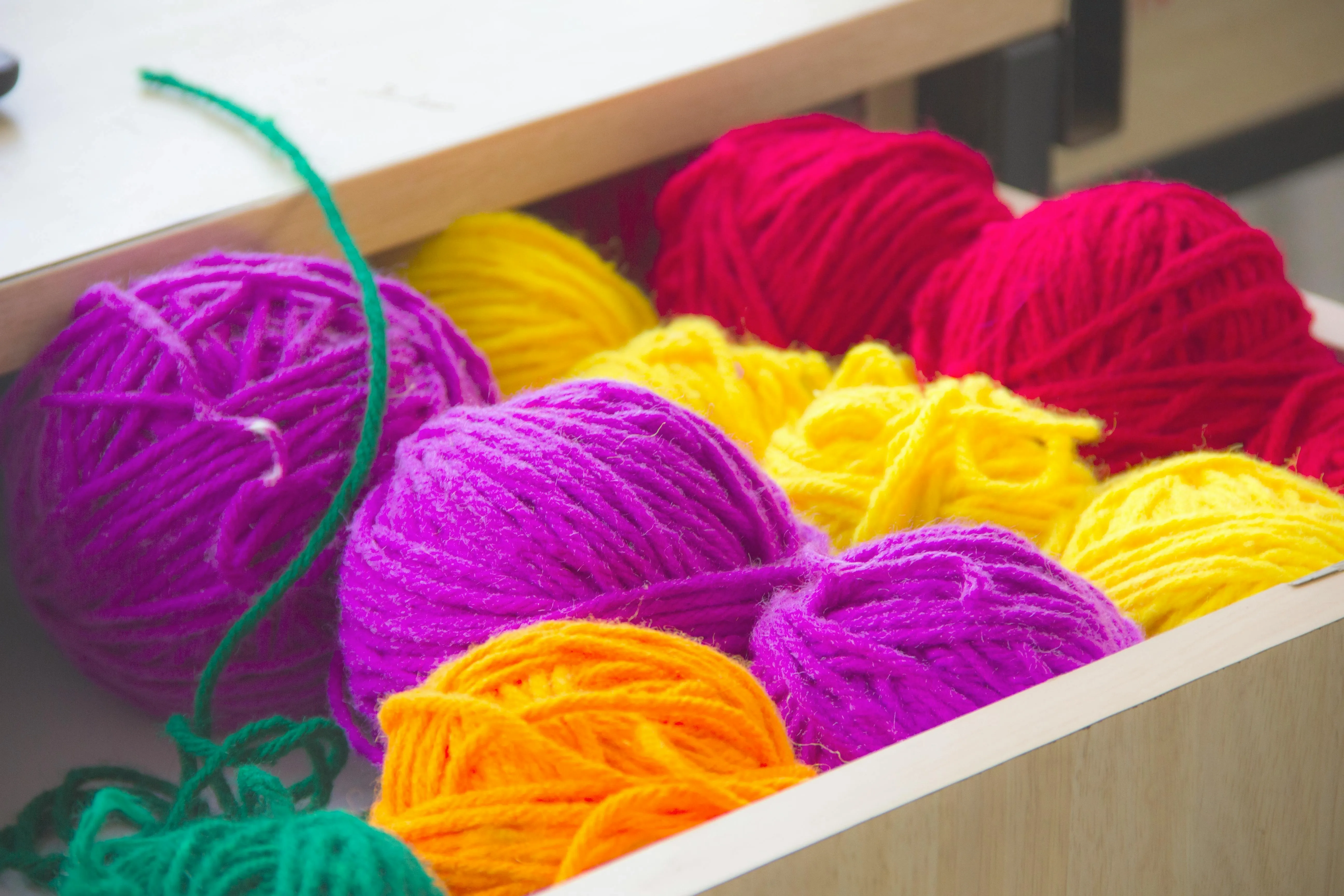 a drawer filled with colorful balls of yarn for best yarn for coasters