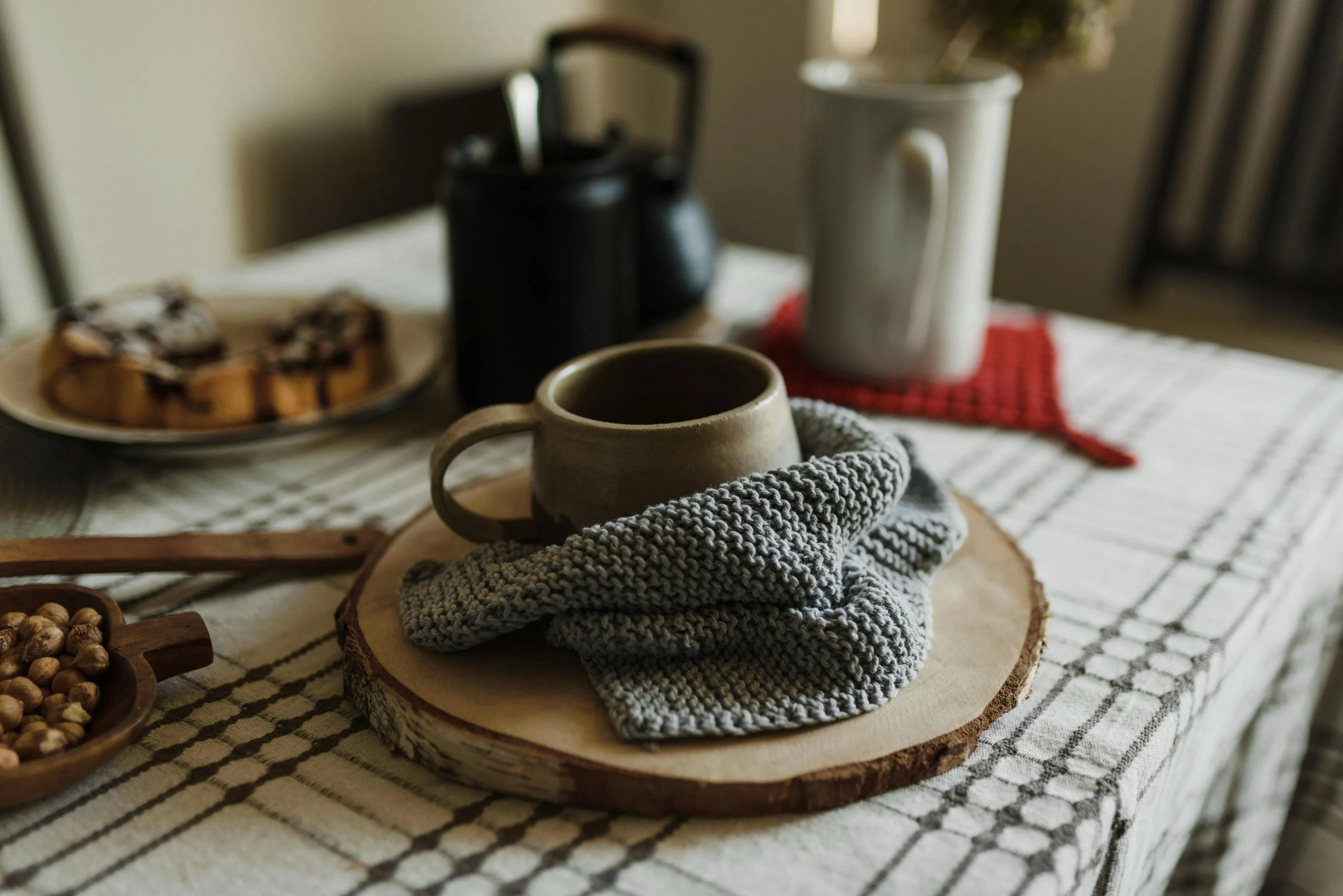 a cup on a wood slice next to some crochet work for best yarn for coasters