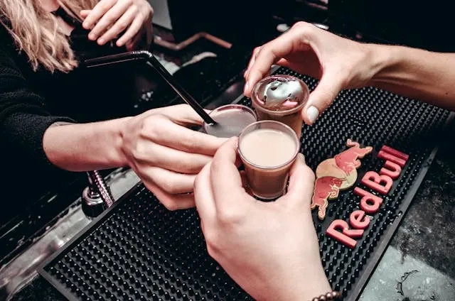 hands holding drinks over a black bar mat for what are bar mats for