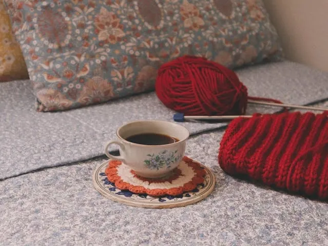 a mug on a coaster beside red yarn for sewing coasters a mug on a coaster beside red yarn for sewing coasters