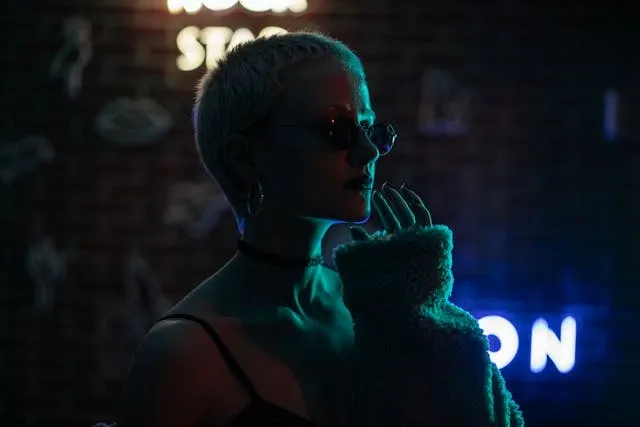 a woman backit by neon signs for nightclub lighting ideas
