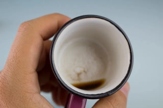 a hand holding an empty cup for how to get coffee stains out of mugs a hand holding an empty cup for how to get coffee stains out of mugs