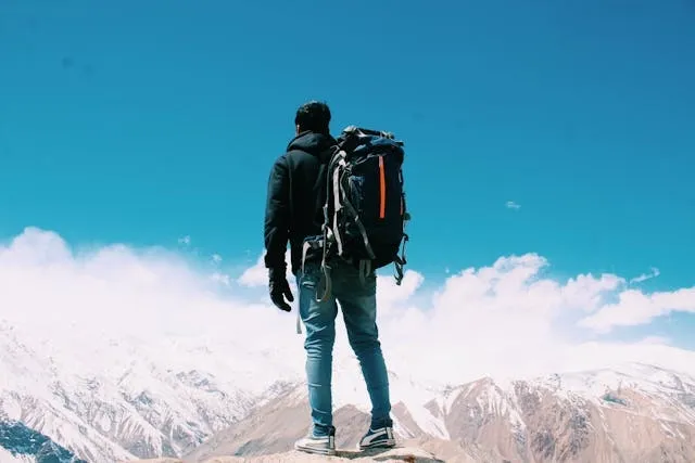 a man standing on top of a mountain for how to wash a backpack a man standing on top of a mountain for how to wash a backpack