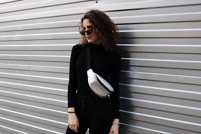 a woman in black wearing a silver fanny pack crossbody for how to wear a belt bag a woman in black wearing a silver fanny pack crossbody for how to wear a belt bag