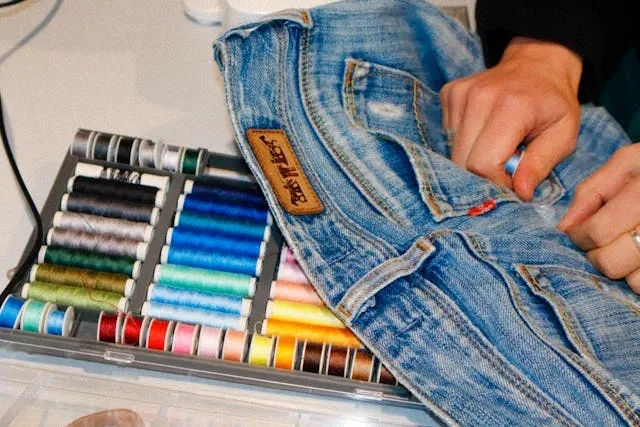 a person preparing to sew on jeans for how to sew on a patch a person preparing to sew on jeans for how to sew on a patch