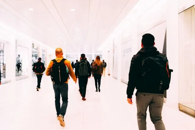 people walking down a white hallway for best everyday backpack people walking down a white hallway for best everyday backpack