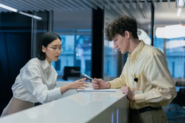 two people looking at documents for how to make badge reels two people looking at documents for how to make badge reels