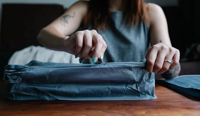 a woman zipping a bag for how to fix a zipper on a backpack a woman zipping a bag for how to fix a zipper on a backpack