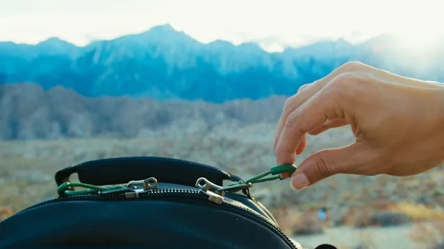 a hand holding a zipper pull tag for how to fix a zipper on a backpack a hand holding a zipper pull tag for how to fix a zipper on a backpack