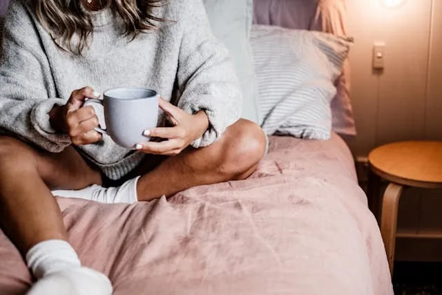 woman sitting on a bed holding a ceramic mug for are ceramic mugs microwave safe woman sitting on a bed holding a ceramic mug for are ceramic mugs microwave safe
