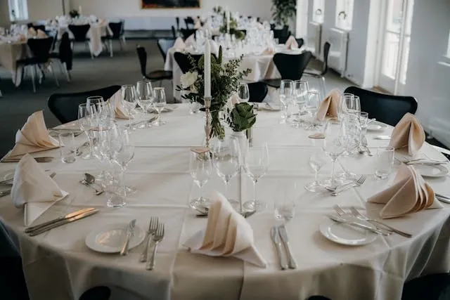 tablewares on a large round table for wedding napkin folds