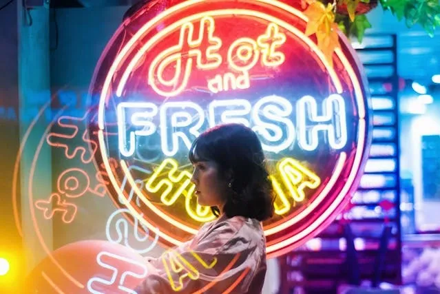 a woman in front of a multi-colored neon sign for best custom neon signs a woman in front of a multi-colored neon sign for best custom neon signs