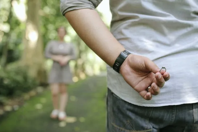 a person holding a ring behind their back for simple proposal ideas a person holding a ring behind their back for simple proposal ideas