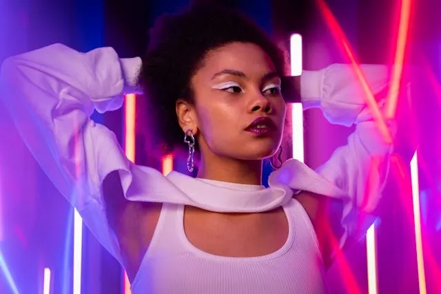 a woman posing beside neon lights for glow in the dark party ideas