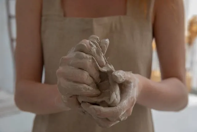 a faceless woman kneading clay in a workshop for clay coasters a faceless woman kneading clay in a workshop for clay coasters