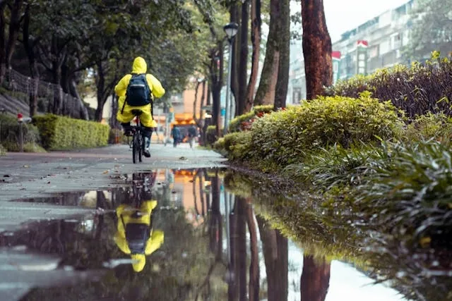 a person cycling in the rain for how to waterproof a backpack a person cycling in the rain for how to waterproof a backpack