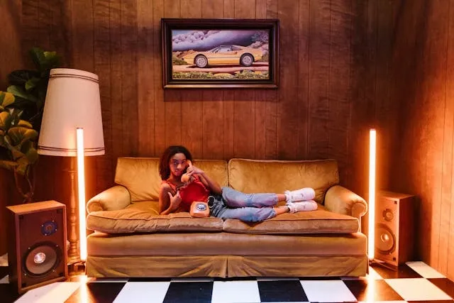 a woman lying on a couch beside neon lighting for neon interior design