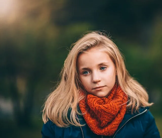 a child wearing an orange scarf for how to wash a scarf